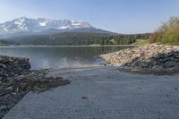 there is a dock next to a lake with mountains in the background and water below