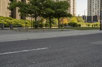 an empty street with many tall buildings in the background and a small white truck is on the right corner