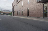 an empty street with a yellow sign on the road and an empty building on the side