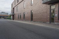 an empty street with a yellow sign on the road and an empty building on the side