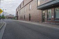 an empty street with a yellow sign on the road and an empty building on the side