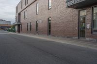 an empty street with a yellow sign on the road and an empty building on the side