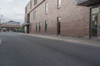 the building is brick with lots of windows, and there is a sidewalk on which to park and walk