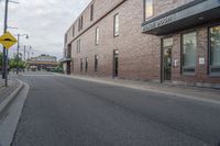 the building is brick with lots of windows, and there is a sidewalk on which to park and walk