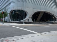 an office building with white accents and stairs outside it, and an empty road near by