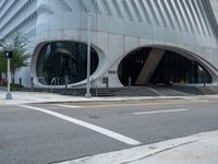 an office building with white accents and stairs outside it, and an empty road near by