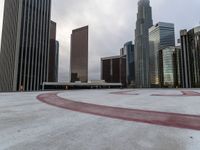 a circle drawn on concrete has been painted with red paint to represent an arrow with tall buildings in the background