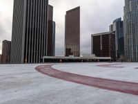 a circle drawn on concrete has been painted with red paint to represent an arrow with tall buildings in the background