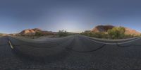 a panoramic lens is reflecting a desert landscape with mountains in the background in this photo