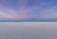 this is a view of the frozen lake under a blue sky with clouds in the background