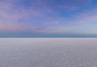 this is a view of the frozen lake under a blue sky with clouds in the background