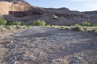 a person stands alone on a trail in the desert with rocks all around them,