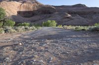 a person stands alone on a trail in the desert with rocks all around them,