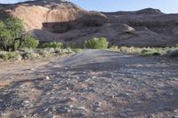 a person stands alone on a trail in the desert with rocks all around them,