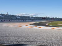 the green road and orange and white stripe line at an event near the racetrack and stadium