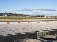 the green road and orange and white stripe line at an event near the racetrack and stadium