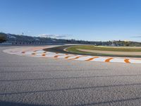 the green road and orange and white stripe line at an event near the racetrack and stadium