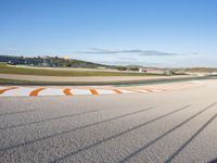 the green road and orange and white stripe line at an event near the racetrack and stadium