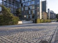 a brick road lined with grass between two buildings and two bicycles on each side of it