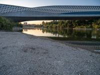 there are two very long bridges that are above the river shore at dusk here, and you can see how close them are