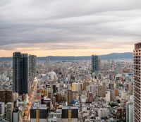 the city is busy with many tall buildings in the foreground and lots of hills