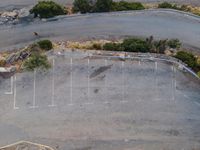 a bird's eye view of a parking lot and some buildings and trees along the street