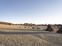 a couple walks together in a large rocky area on the desert with little rock formations