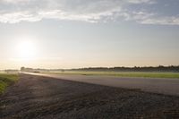 the back of a motorcycle is traveling on a deserted road at sunset - like conditions