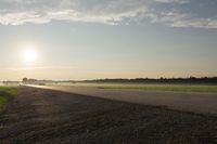 the back of a motorcycle is traveling on a deserted road at sunset - like conditions