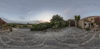 the view of an outdoor courtyard from 360 lens perspective with a cloudy sky in the background