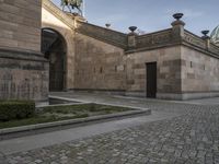 an entrance in front of a church with a statue on the roof and outside walls