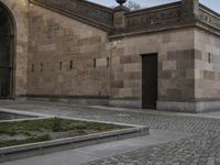 an entrance in front of a church with a statue on the roof and outside walls