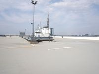 a boat is parked in an empty parking lot near an air port on the water