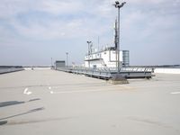 a boat is parked in an empty parking lot near an air port on the water