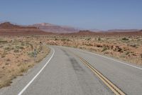 the desert has two roads that are open to traffic with desert in the background and mountain ranges