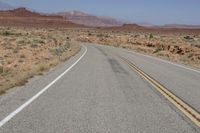 the desert has two roads that are open to traffic with desert in the background and mountain ranges