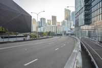 the city street has a building on it in the background, palm trees and other tall buildings