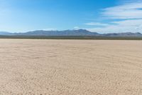 a motorcycle is parked on the flat desert road in the middle of nowhere and no one around