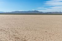 a motorcycle is parked on the flat desert road in the middle of nowhere and no one around