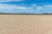 a motorcycle is parked on the flat desert road in the middle of nowhere and no one around