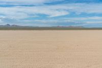 a motorcycle is parked on the flat desert road in the middle of nowhere and no one around