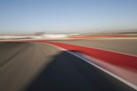 Daytime Highway: Red Car Against a Clear Sky