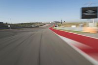 blurry photo of an automobile track with the sign above the camera lens at the moment