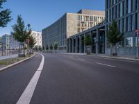 an empty city street is seen on a sunny day in this image, with a bus driving