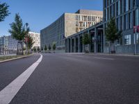 an empty city street is seen on a sunny day in this image, with a bus driving