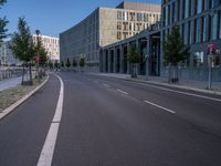 an empty city street is seen on a sunny day in this image, with a bus driving