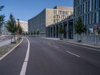 an empty city street is seen on a sunny day in this image, with a bus driving