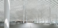 this room has many metal columns and a ceiling covered in netting on the ceiling is a tv that is in front of it