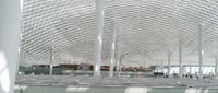 this room has many metal columns and a ceiling covered in netting on the ceiling is a tv that is in front of it