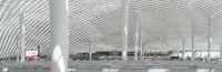this room has many metal columns and a ceiling covered in netting on the ceiling is a tv that is in front of it
